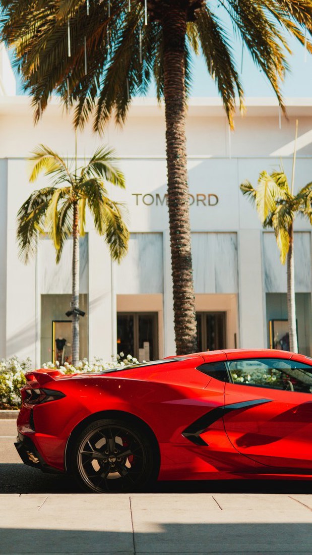 Red Sports Car on Palm-Lined Street